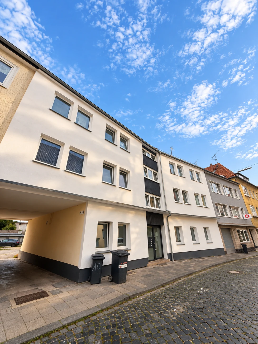 Wohn- und Geschäftshaus mit heller Fassade und ebenerdiger Gewerbefläche